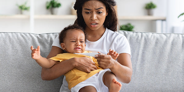 Mom holding baby with fever - Baby Shusher